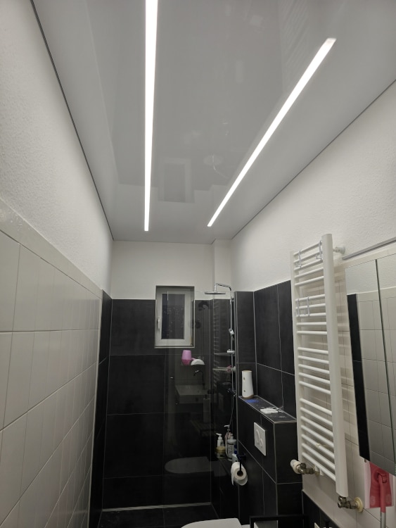 Lackspanndecke mit Lichtlinien im Badezimmer